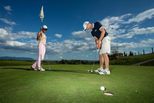 a man and a woman playing a game of golf at Laguna Palace Hotel Grado in Grado