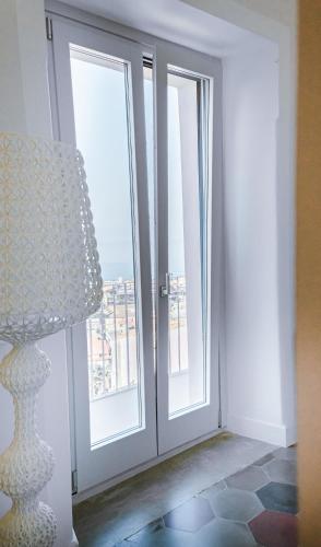a room with a door and a lamp and a window at Dimora Cavour in Amantea