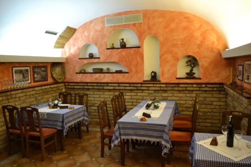 a restaurant with two tables and chairs and a brick wall at Guesthouse Kruna Višegrad in Višegrad