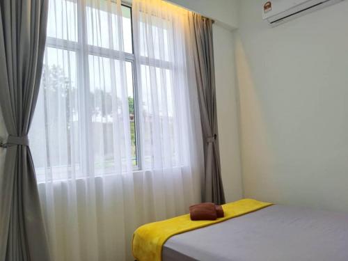 a bedroom with a bed and a large window at ezzahrahsyariahhomestay in Sandakan