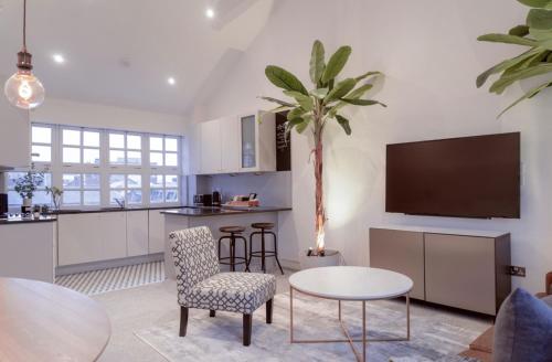a kitchen and living room with a table and a tv at Luxury Apartment In The Heart of Leicester With Parking in Leicester