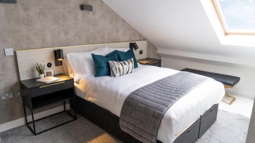 1 dormitorio con 1 cama grande con almohadas azules en Luxury Apartment In The Heart of Leicester With Parking, en Leicester