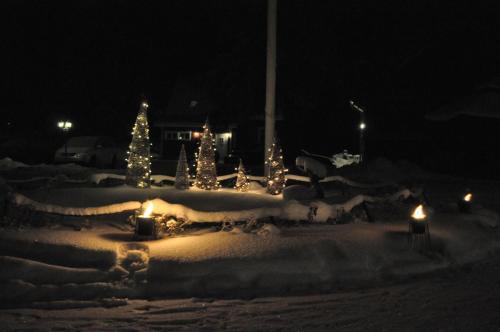 a yard covered in snow with candles and christmas trees at Vaihmalan Hovi in Lempäälä