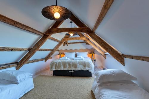 a attic bedroom with a bed and two twin beds at Finest Retreats - The Half-ARC of Padstow in St. Issey