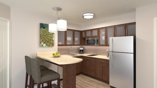 a kitchen with a white refrigerator and wooden cabinets at Staybridge Suites - Nashville - Franklin by IHG in Franklin