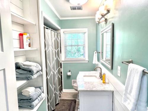 ein Badezimmer mit einem Waschbecken und einer Dusche mit Handtüchern in der Unterkunft The Best Family & Friends Hangout & Pet Friendly!! in Wilmington