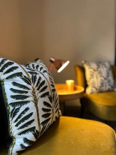a living room with a couch with a pillow and a lamp at Honeysuckle Cottage & Whinfell Studio in Penrith