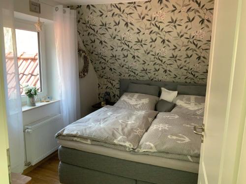 1 dormitorio con 1 cama y papel pintado con motivos florales en FeWo "Zwischen den Meeren" en Rendsburg