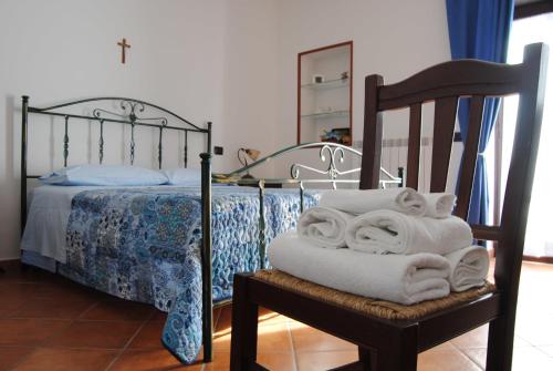 a bedroom with a bed with towels on a chair at Casale San Felice B&B in Cusano Mutri