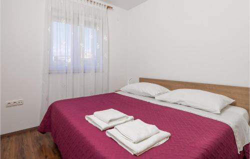Cozy Apartment In Povljana With Lake View في بوفليانا: سرير مع بطانية ارجوانية ومخدات بيضاء