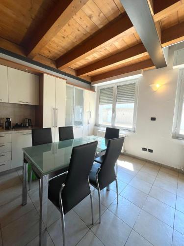 a dining room with a glass table and chairs at Easy Milano - Rooms and Apartments Navigli in Milan