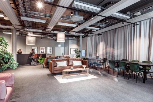 a living room with couches and a table and chairs at Stockholm Hotel Apartments Arlanda XPO in Arlanda