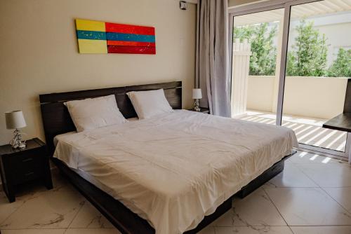 a bedroom with a large bed and a large window at Best quality 2-bedroom apartment 2 km from Eagle beach in Palm-Eagle Beach