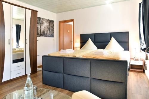 a bedroom with a large bed with a glass table at RATAGS Kunsthandwerkerhaus in Langenwolmsdorf