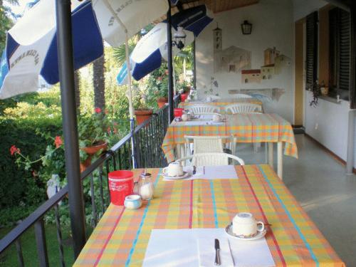 un balcone con due tavoli e un ombrellone di Garni Molinazzo ad Agno