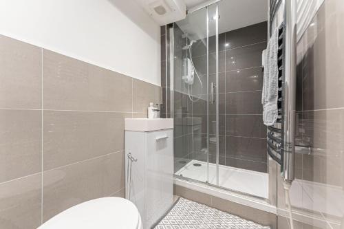 a bathroom with a toilet and a shower at Tanna Estates - George Street House in Leamington Spa