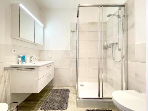 a white bathroom with a shower and a sink at Pärchentraum im Zentrum von Graz in Graz