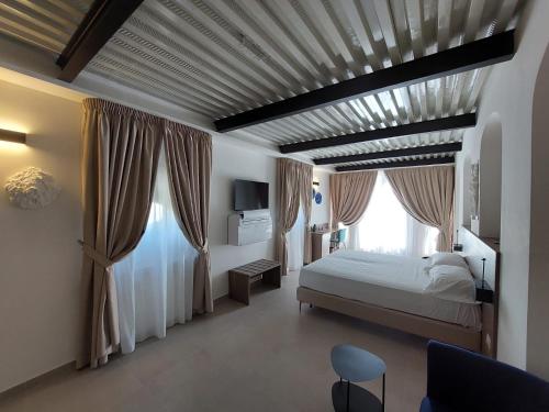 Boutique Hotel Palazzo Donna Iulia في بوتسولي: غرفة نوم بسرير ونافذة كبيرة