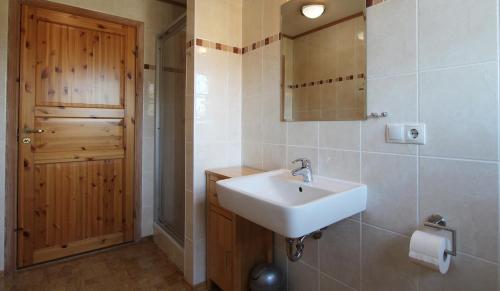uma casa de banho com um lavatório e uma porta de madeira em Haus Norway Trondheim em Wittenbeck