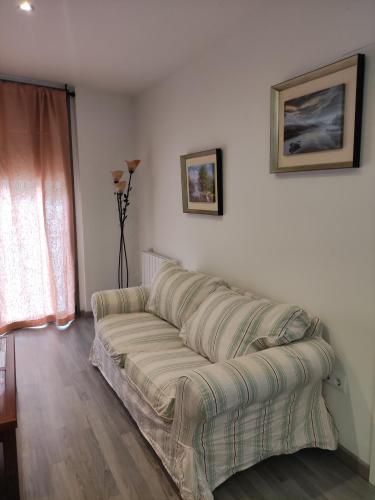 a couch sitting in a living room next to a window at La LLana Nova in Ribes de Freser