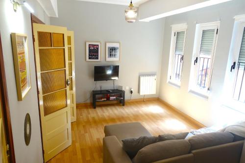 sala de estar con sofá y TV en Yellow Door 2, en Ponferrada