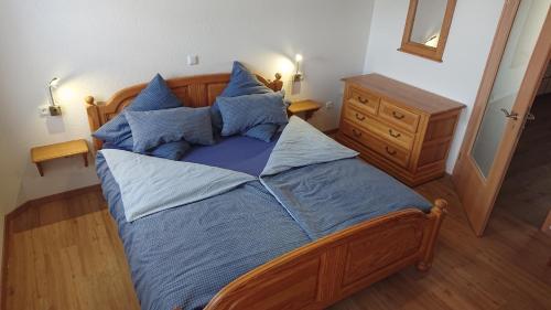 a bedroom with a large bed with blue sheets and pillows at Schmugglerhaus in Losheim