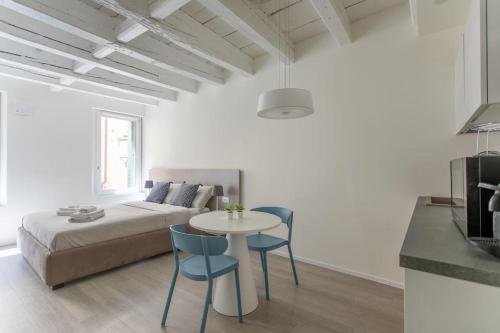 a living room with a bed and a table and chairs at Residenza SubitoSanto - Appartamento 2A "Angelina" in Padova