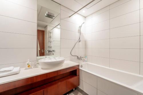 a white bathroom with a sink and a tub at GUEST READY - Luxury One Bedroom Apartment DIFC Burj Khalifa View in Dubai