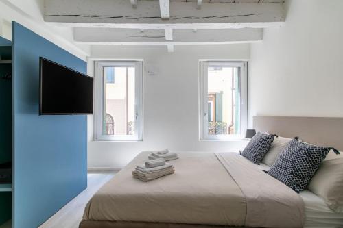 a bedroom with a bed and a flat screen tv at Residenza SubitoSanto - Appartamento 2A "Angelina" in Padova