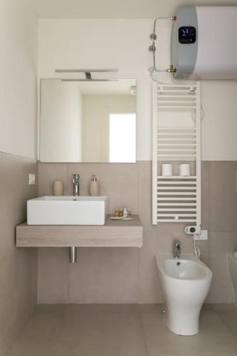 a white bathroom with a sink and a mirror at Residenza SubitoSanto - Appartamento 2A "Angelina" in Padova