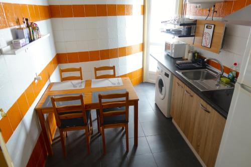 una pequeña cocina con mesa, sillas y fregadero en Yellow Door 2, en Ponferrada