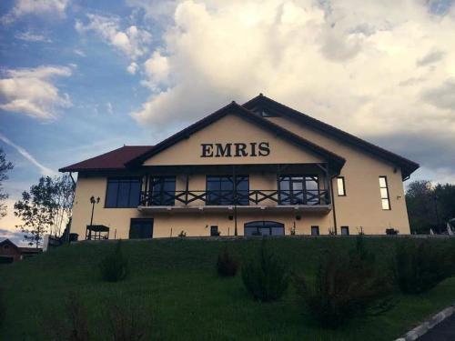 a building with the word emrs written on it at Pensiunea Emris in Spătac