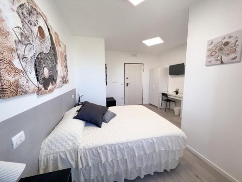 biała sypialnia z łóżkiem i biurkiem w obiekcie A casa di Asja w mieście Terni