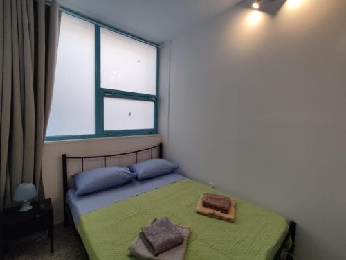 een slaapkamer met een bed met 2 kussens en een raam bij PURE URBAN ACROPOLIS METRO PETRALONA in Athene
