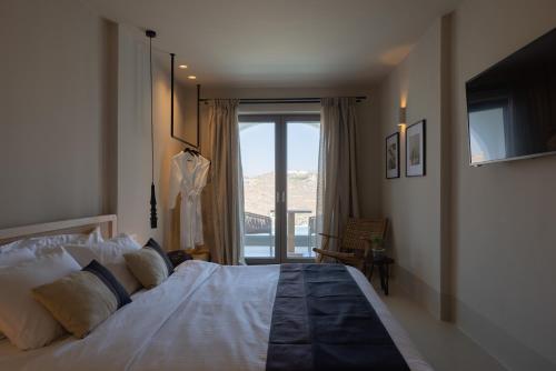 una camera da letto con un grande letto con una grande finestra di Nimbus Lumen a Super Paradise Beach