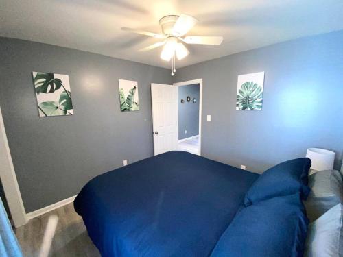 a bedroom with a blue bed and a ceiling fan at The Best Getaway Friends & Family Hangout!!! in Jacksonville