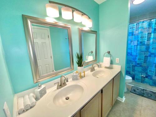 a bathroom with two sinks and a large mirror at The Best Getaway Friends & Family Hangout!!! in Jacksonville