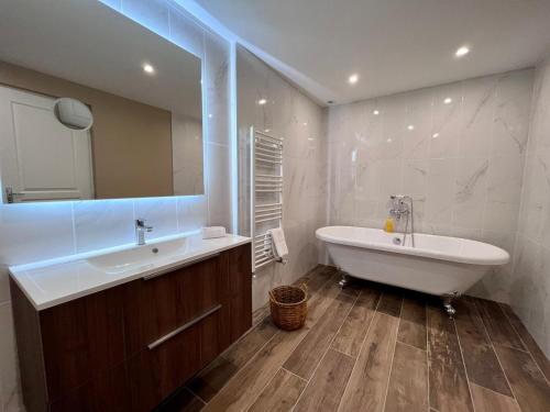 een badkamer met een bad en een wastafel en een ligbad bij L'Envie d'Eymet, gîte pour 6 personnes in Eymet