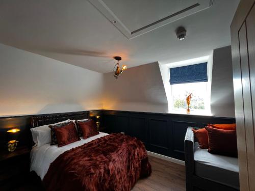 a bedroom with a bed and a window and a couch at Chapel Cross Guesthouse in Roslin