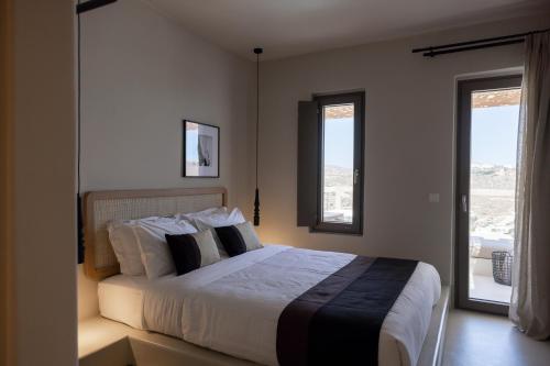 a bedroom with a large bed and two windows at Nimbus Lumen in Super Paradise Beach