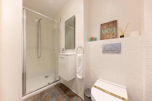 a white bathroom with a shower and a toilet at Bravissimo Eiximenis, with beautiful terrace and views in Girona