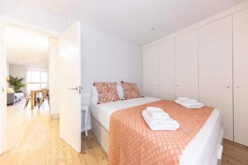 ein weißes Schlafzimmer mit einem Bett und weißen Schränken in der Unterkunft Bravissimo Eiximenis, with beautiful terrace and views in Girona