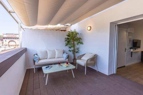 a living room with a couch and a table at Bravissimo Eiximenis, with beautiful terrace and views in Girona