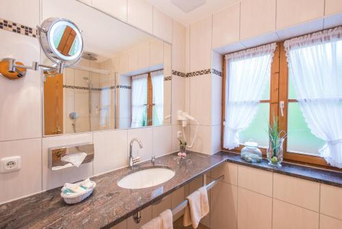 a bathroom with a sink and a mirror at Hotel Alpspitz B&B in Grainau