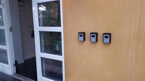 een muur met twee mobiele telefoons aan de zijkant van een huis bij B&B Fryden Ly in Horsens
