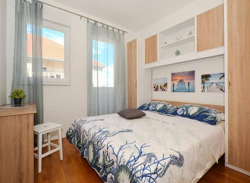 um quarto com uma cama, uma secretária e uma janela em Apartment Charlie em Podstrana