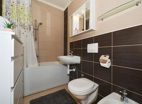 uma casa de banho com um WC, um lavatório e uma banheira em Apartment Charlie em Podstrana