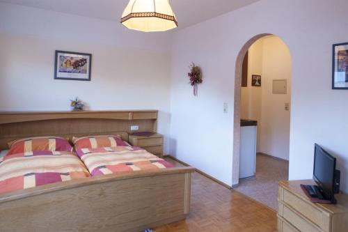 a bedroom with a bed and a flat screen tv at Haus Schönegger in Dorfgastein