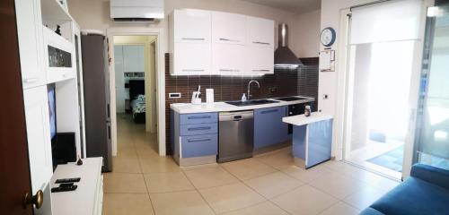 una cocina con armarios blancos y electrodomésticos azules en Delizioso appartamento nel cuore Castelli Romani, en Marino