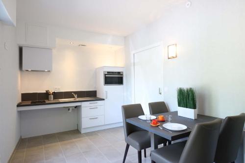 a kitchen with a table and chairs in a room at Le Vieux Moulin in Hédé